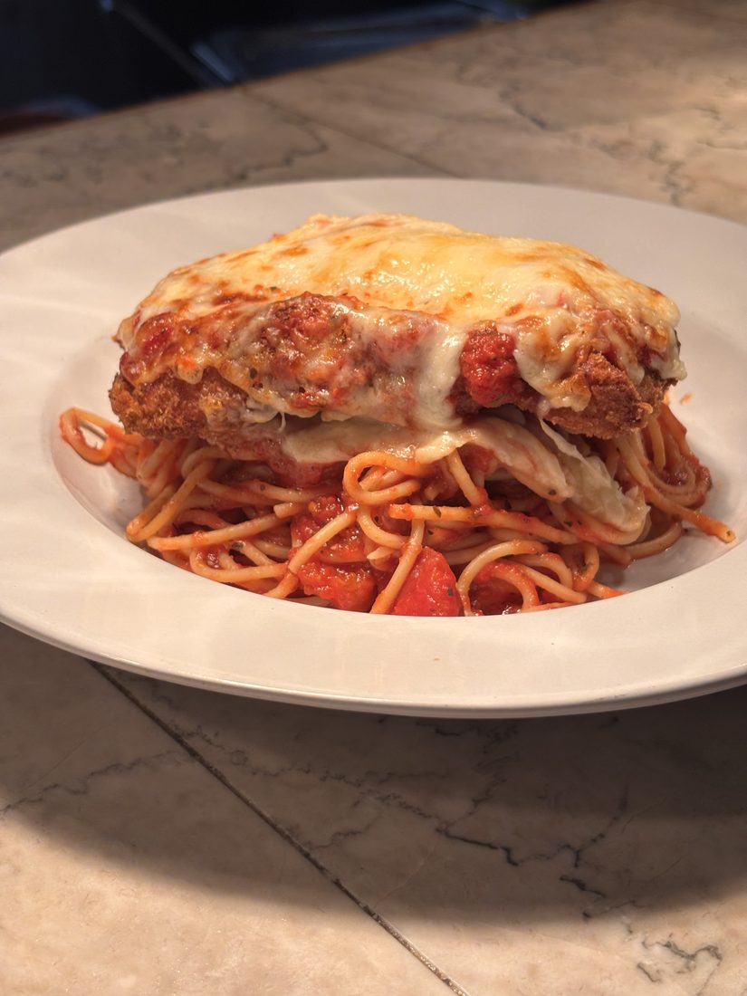 Chicken Parmesan with melted cheese and marinara over spaghetti